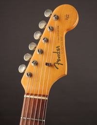 Close-up of a Fender guitar headstock on a dark background