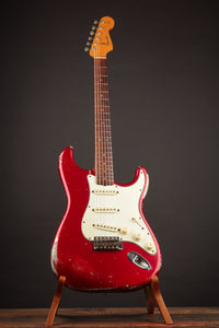 1964 candy apple red Fender Stratocaster  electric guitar on a stand against a dark background