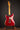 1964 candy apple red Fender Stratocaster  electric guitar on a stand against a dark background, back view