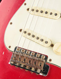 Close-up of pickguard and bridge on a 1964 candy apple red Fender Stratocaster 