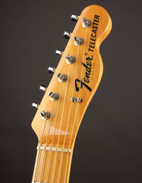 Close-up of a 1968 Fender Telecaster Custom guitar headstock on a dark background