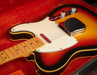 Close-up of a Sunburst 1968 Fender Telecaster Custom guitar, in original hardshell case with red lining.