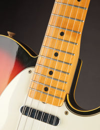 Close-up of a Telecaster guitar neck and body with a dark background
