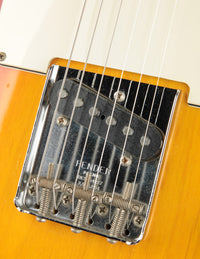 Close-up of a Fender guitar bridge with strings