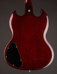 Back view of a red electric guitar on a dark background
