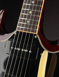 Close-up of a guitar neck and pickup with a dark background