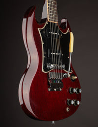 Red electric guitar on a dark background