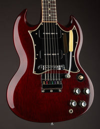 Red electric guitar on a dark background