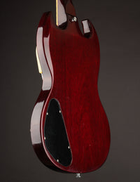 Red electric guitar body on a dark background