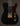 Black electric guitar with gold hardware on a dark background