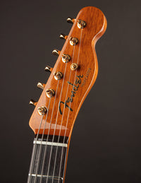 Close-up of a Fender guitar headstock on a dark background
