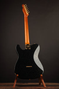 Black electric guitar with a unique design on a stand against a dark background