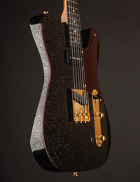 Black glittery electric guitar with gold hardware on a dark background