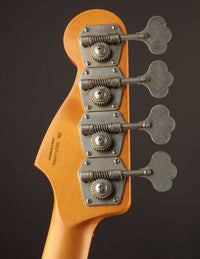 Close-up of a guitar headstock with tuning pegs on a dark background