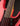 Close-up of a red electric bass guitar's neck joint with a dark background