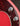 Close-up of a red electric guitar with control knobs on a dark background
