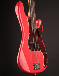 Red electric bass guitar on a black background