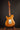 Electric guitar on a stand against a dark background