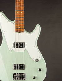 Electric guitar with a light green body and brown neck on a dark background