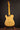 Wooden electric guitar on a stand against a dark background