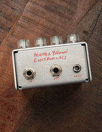 Guitar effects pedal with 'Heather Brown Electronics' branding on a wooden surface