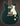 Dark green topped Healy electric guitar against a dark background. 