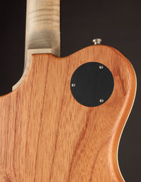 Close-up of a wooden guitar body with a dark background