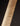 Close-up of a figured maple guitar neck with visible grain pattern on a dark background