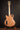 Wooden electric guitar on a stand against a dark background