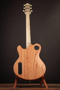 Wooden electric guitar on a stand against a dark background