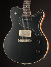 Black electric guitar with a dark background