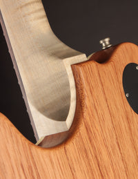 Close-up of a guitar's wooden neck and sculpted neck pocket.