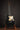 Black electric guitar on a stand against a dark background