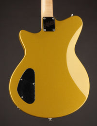 Gold electric guitar on a dark background, back view