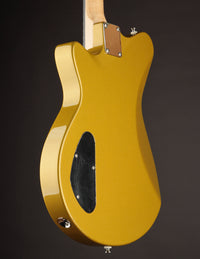 Gold electric guitar with a white pickguard on a dark background, back/side view