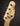 Close-up of a bass guitar headstock with tuning pegs on a dark background