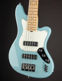 Light blue electric bass guitar on a black background