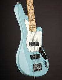 Light blue electric bass guitar on a black background
