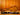 Open guitar case on a wooden floor with a wooden wall background