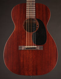 Acoustic guitar with a dark brown finish on a gray background