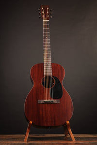 Acoustic guitar on a stand against a dark background