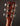 Close-up of a guitar headstock with tuning pegs on a dark background
