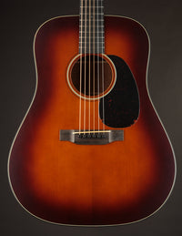 Martin acoustic guitar with a sunburst finish on a dark background