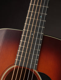 Close-up of an acoustic guitar's neck on a dark background