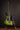 Green electric guitar on a stand against a dark background