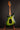 Green electric guitar on a stand against a dark background