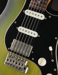 Close up of green and black electric guitar on a dark background