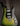 Green and black electric guitar on a dark background