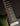 Close-up of a guitar neck with frets and strings on a dark background
