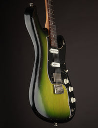 Green and black electric guitar on a dark background